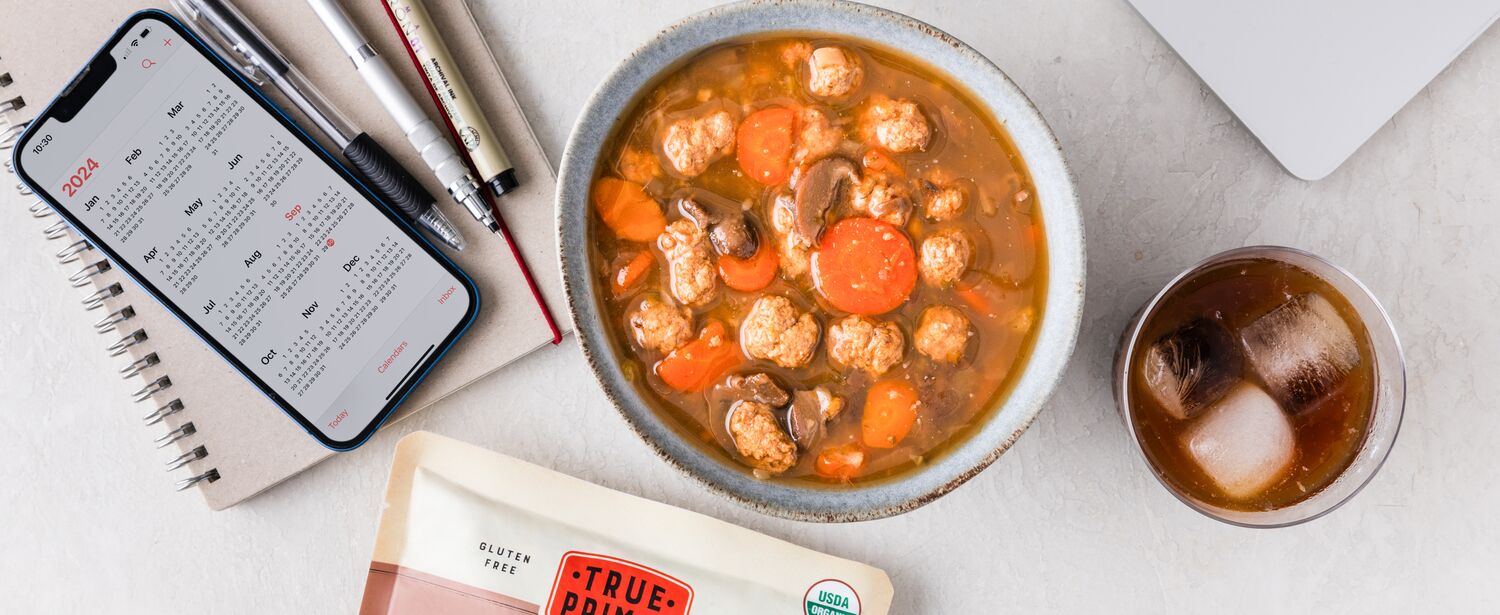 Beef & Mushroom Organic Soup in bowl next to pouch